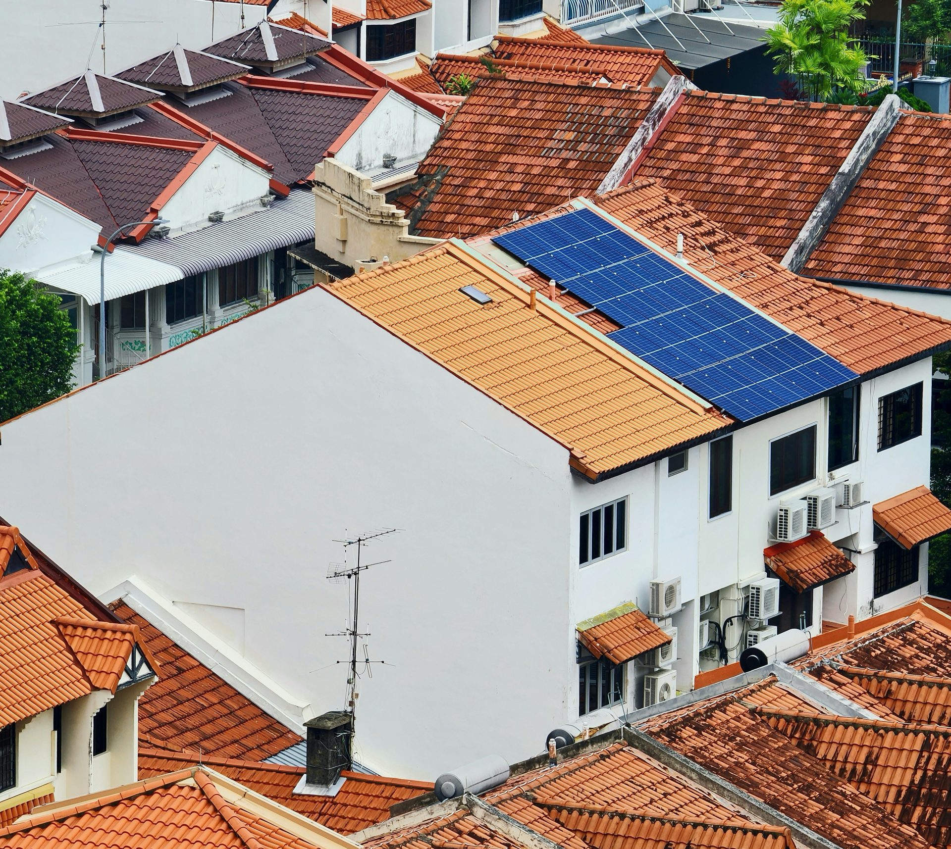 Hausdächer, wobei eines der Dächer mit Solarpaneelen versehen ist.